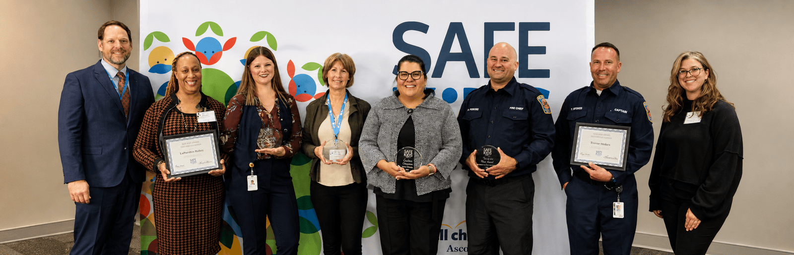 Safe Kids Austin award recipients holding community safety certificates and plaques