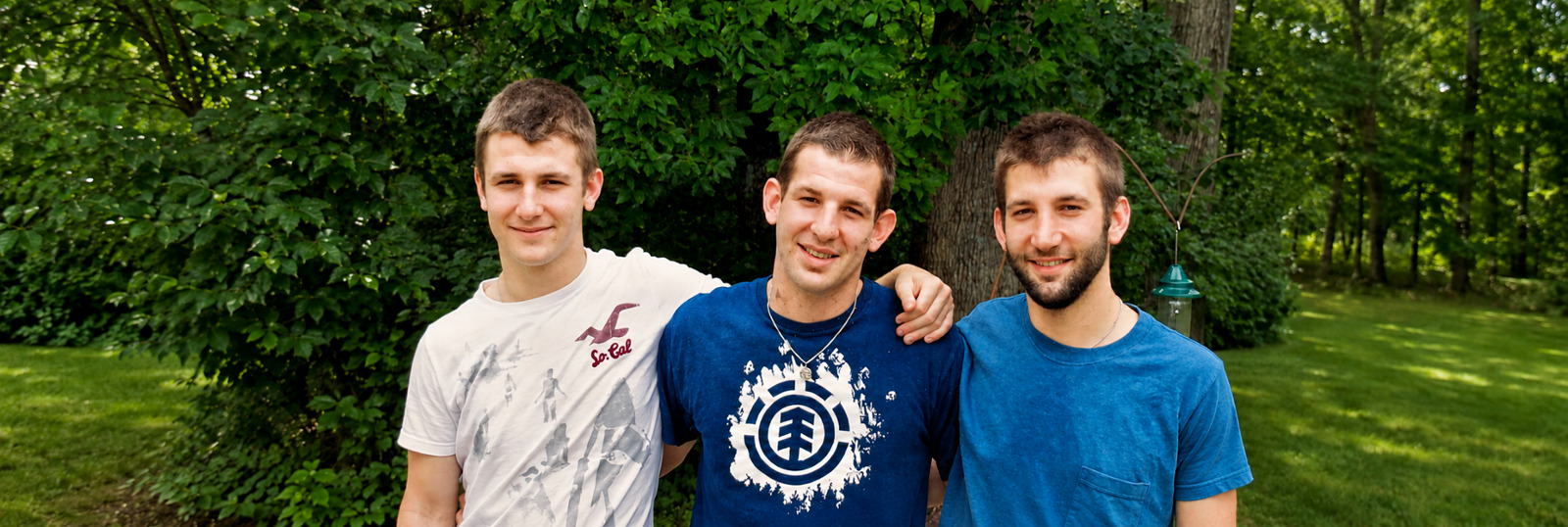 Jon standing outdoors with his two brothers