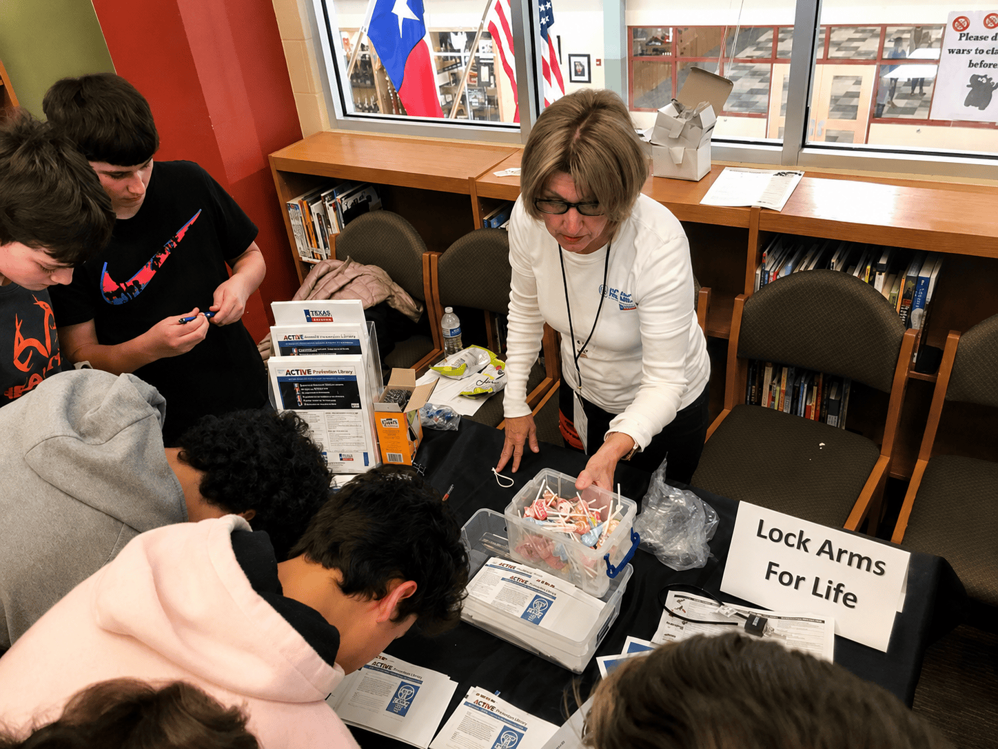 Lock Arms for Life volunteer sharing firearm safety resources with students at a school event